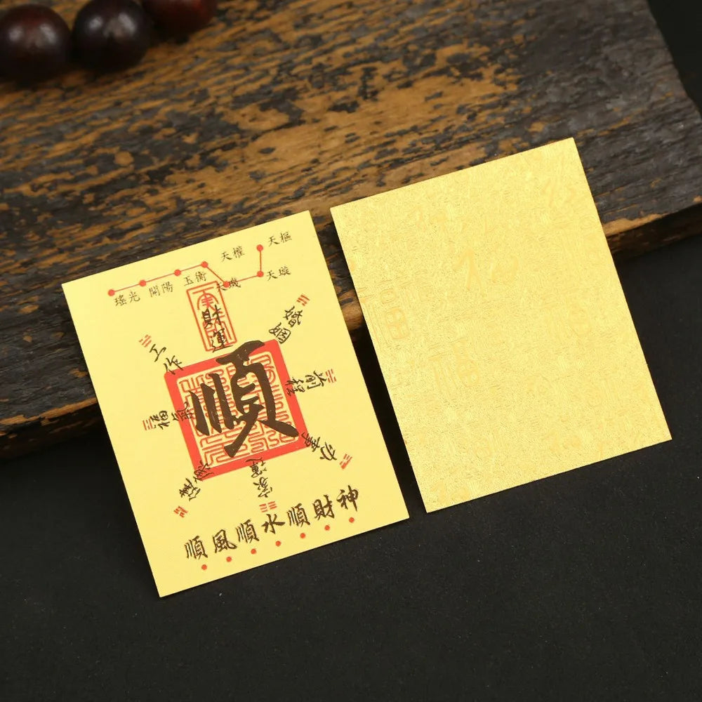 A yellow sticker with red Chinese characters for lucky wealth and prosperity is placed on a dark wooden surface.