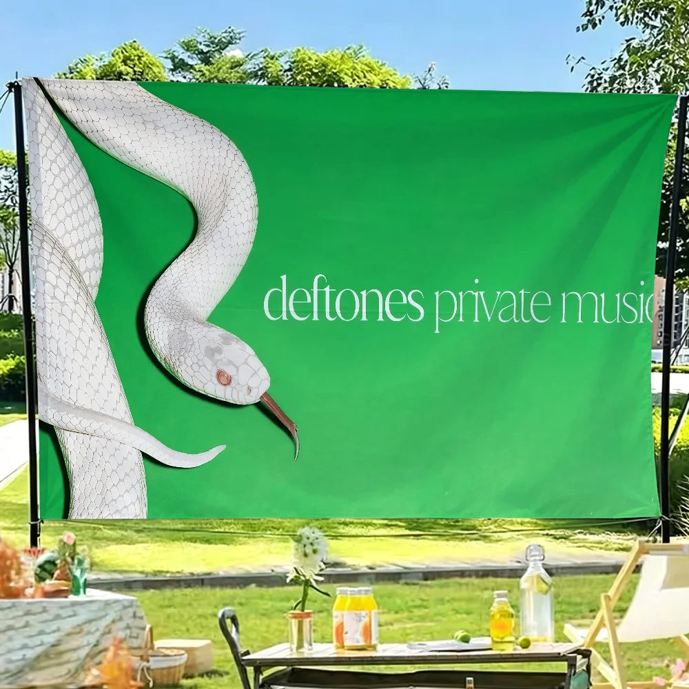 A green flag featuring a white bird silhouette and the text deftones private music displayed outdoors.