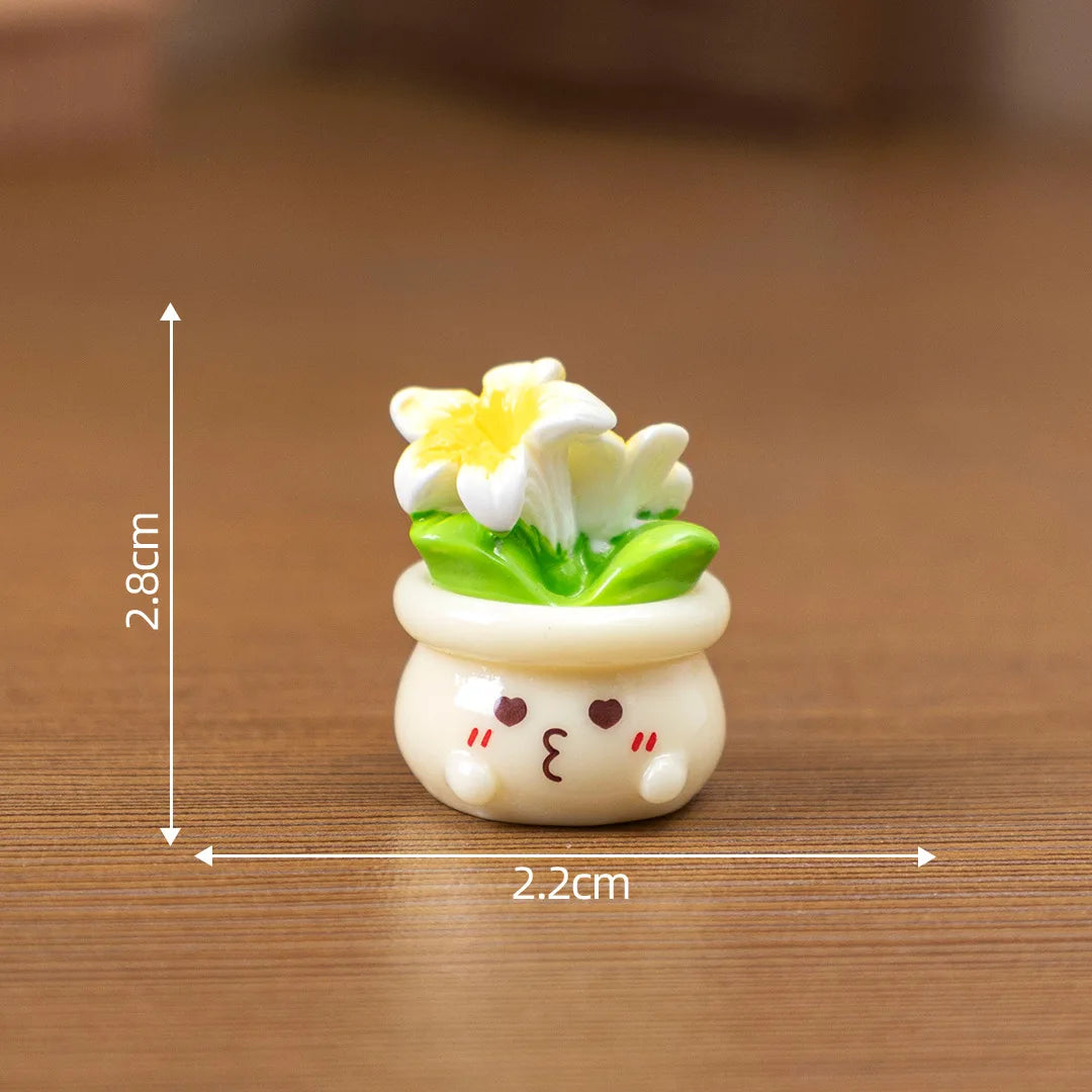 A small white resin charm shaped like a potted yellow and white flower with a cute face, displayed on a wooden surface.