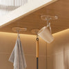 A set of transparent self-adhesive hooks is shown hanging from a ceiling fixture above a towel rack.