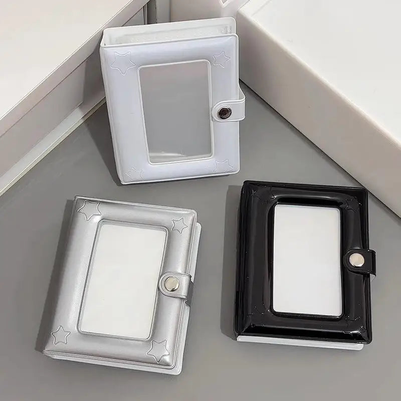 A set of two mini photo card binders, one white and one black, displayed on a gray surface.