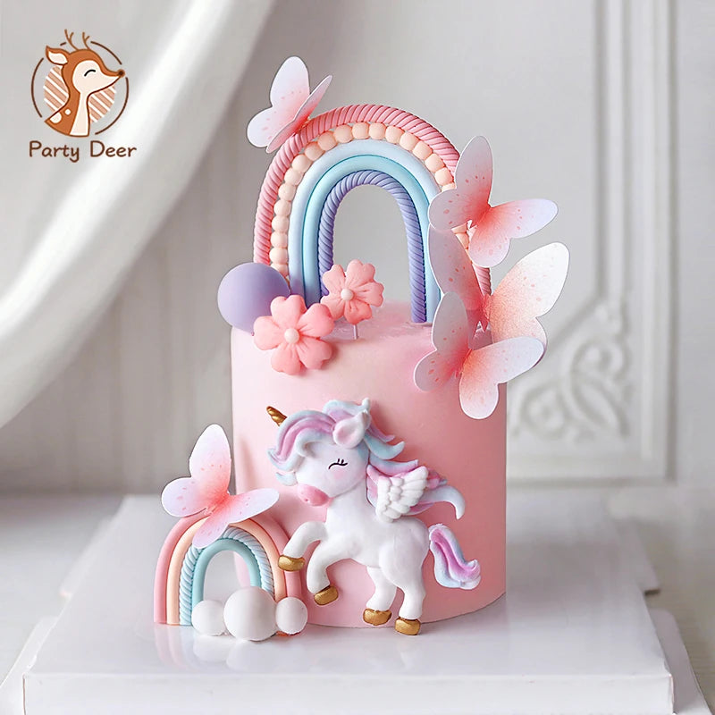 Pink unicorn theme cake topper set featuring a rainbow arch and pink butterfly decorations