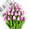 A bouquet of pink tulips with green stems and leaves, arranged for decoration.