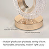 A modern crystal table lamp with a gold base and clear glass shade featuring touch switch and long press dimming controls.