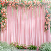 A pink floral backdrop featuring draped sheer vines and roses against a soft pink curtain.