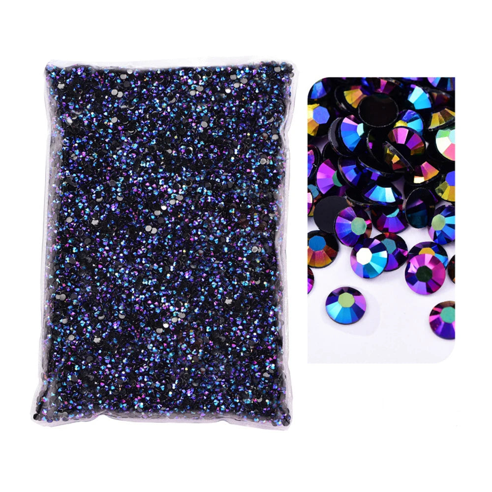 A clear bag filled with black glitter and a separate pile of iridescent resin rhinestones