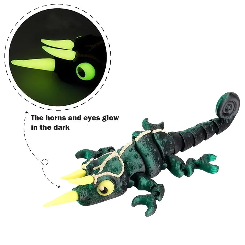 A dark green chameleon fidget toy with glowing yellow horns and eyes, shown next to a magnified view of the glow.