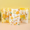 Three clear honeycomb patterned gift bags filled with honey for party favors