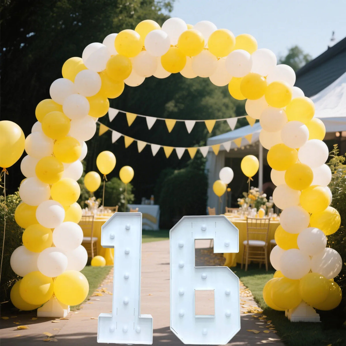 A large marquee sign shaped like the number 16 made of white light bulbs is displayed within a yellow and white balloon archw