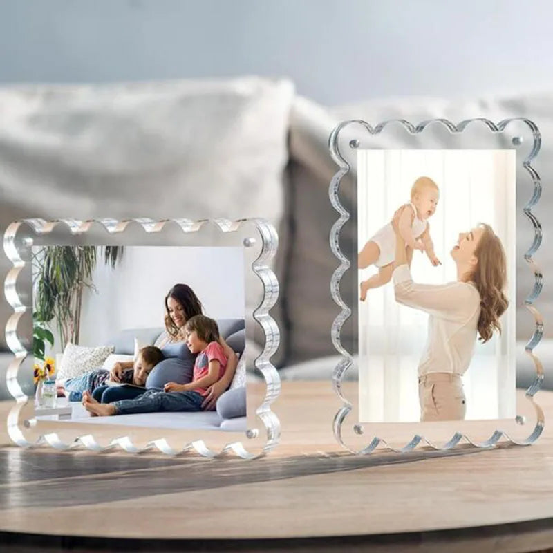 A clear acrylic photo display frame with a decorative border holds a picture of a mother holding a baby.