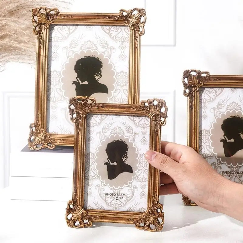 A hand holds a gold-framed resin photo frame featuring a silhouette of a woman against a white background.