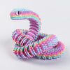 Lebendiges, mehrfarbiges 3D-gedrucktes Schlangen-Fidget-Spielzeug mit Schuppen in Rosa-, Lila- und Blautönen.