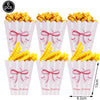 A set of six pink paper cups filled with yellow corn puffs and decorated with pink bows for a birthday party.