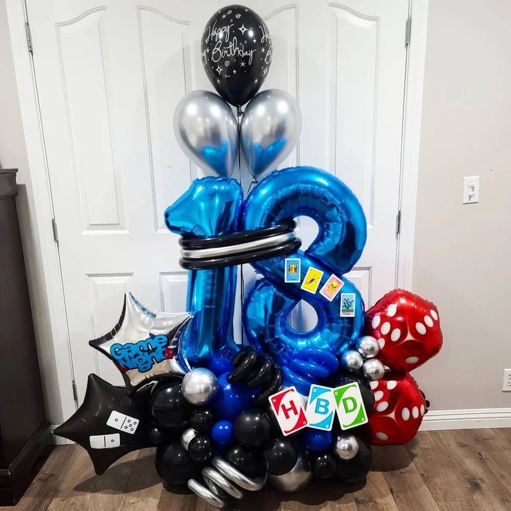 A balloon bouquet featuring silver, blue, and black foil balloons shaped like the number 2 and various other shapes for a par