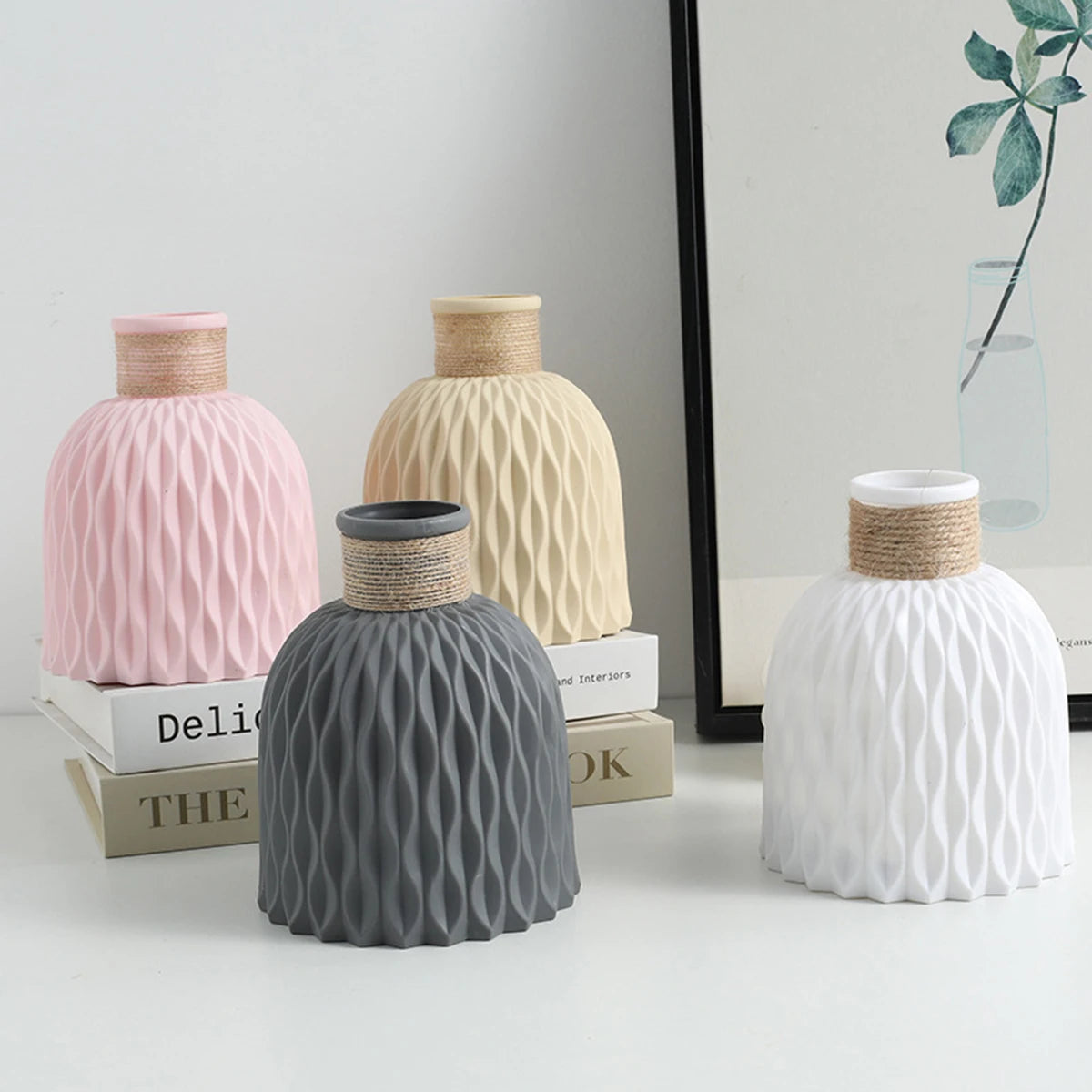 Three ceramic vases in pink, cream, and white with vertical ripple textures displayed on a white surface.
