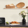A wooden cutting board holds slices of toast against a light tiled wall backdrop.