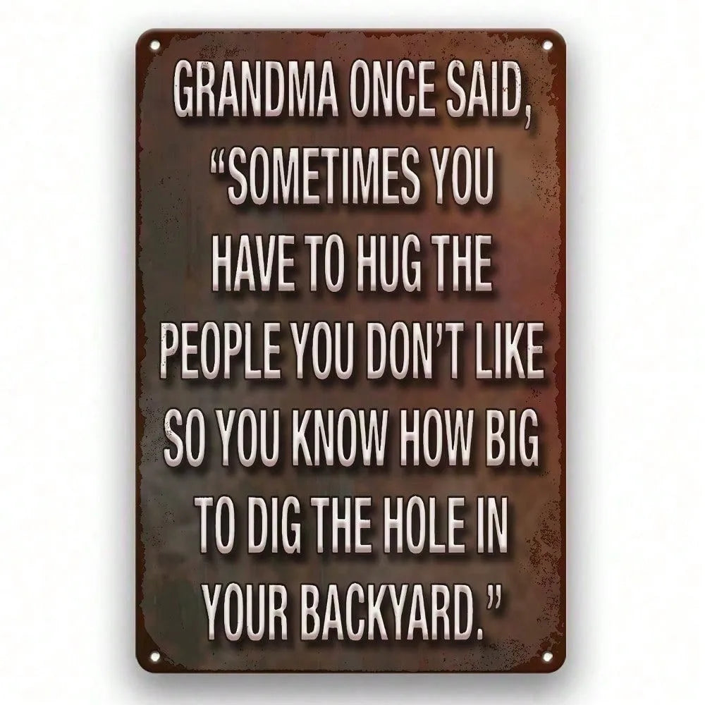 A dark metal wall sign with white text featuring a quote about hugging people you dislike.