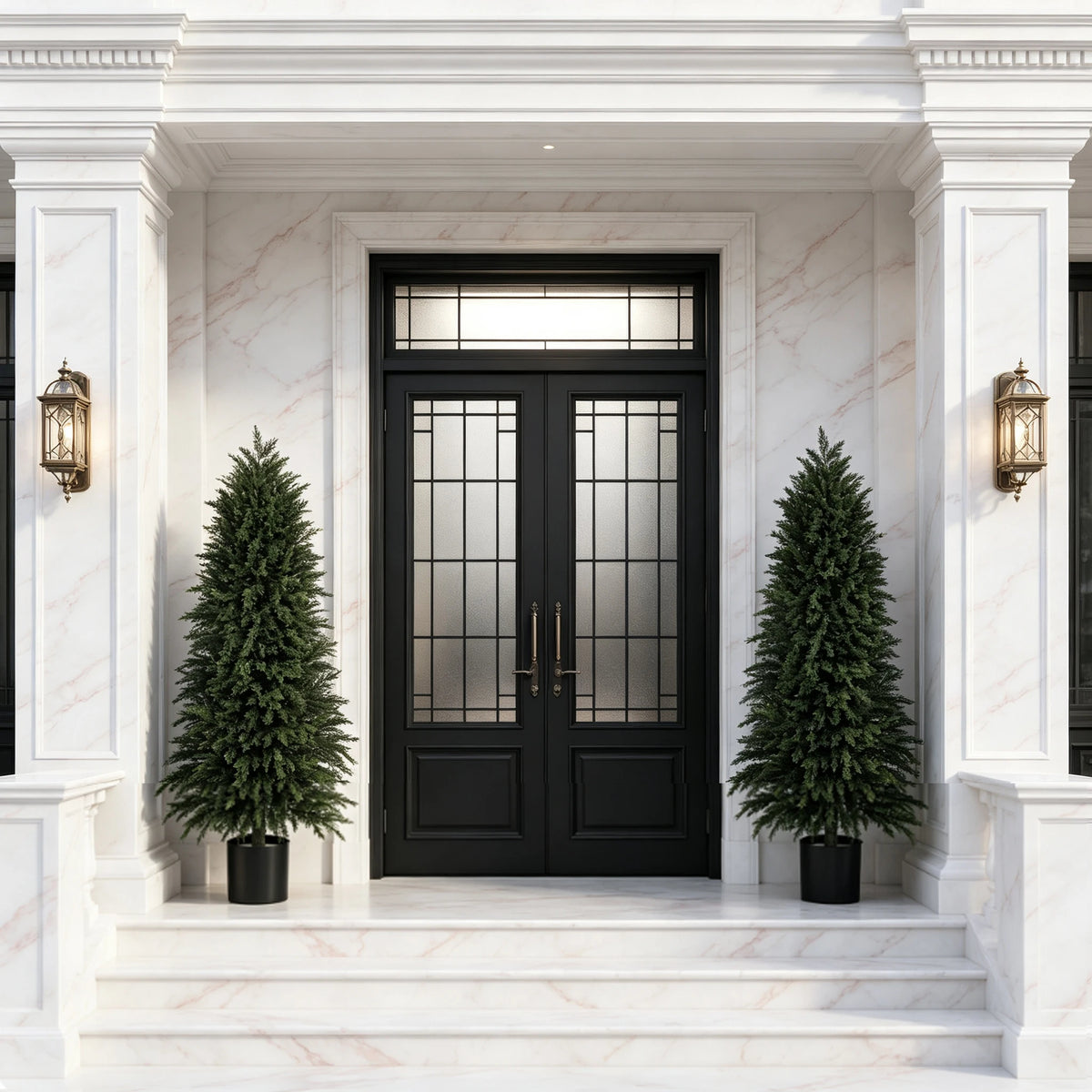 A pair of tall artificial cedar topiary trees flanking a white marble entryway with a black door.