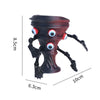 A dark, sculpted replica of a monster head with large eyes and spindly arms, measuring 8.5 cm tall.