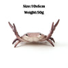 A small, realistic crab-shaped desk organizer with a light brown and white color scheme.