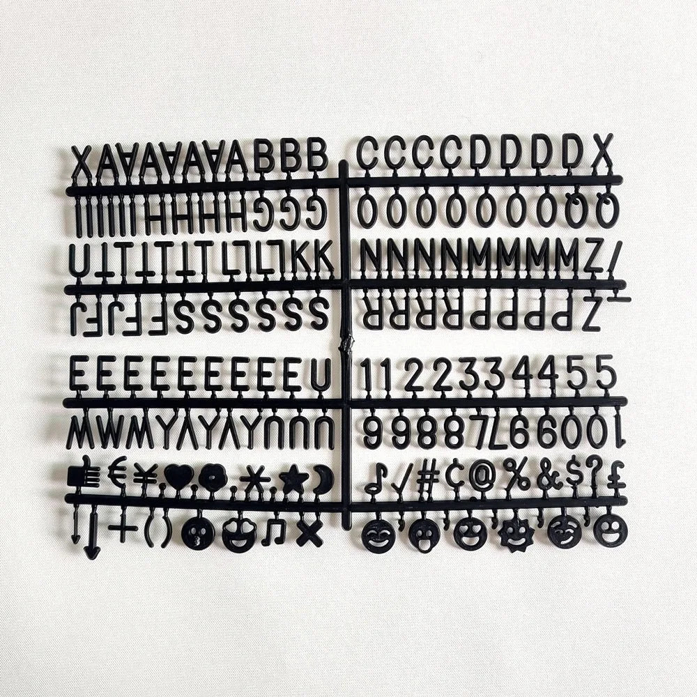A black wooden message board featuring various symbols, letters, and punctuation marks arranged in a grid.