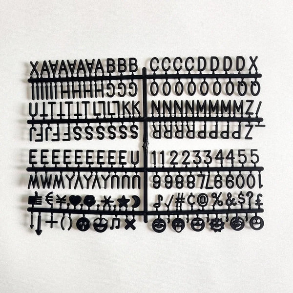 A black wooden message board featuring various symbols, letters, and punctuation marks arranged in a grid.