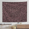 A close-up of a wall tapestry featuring a dense leopard print pattern in shades of pink and black.