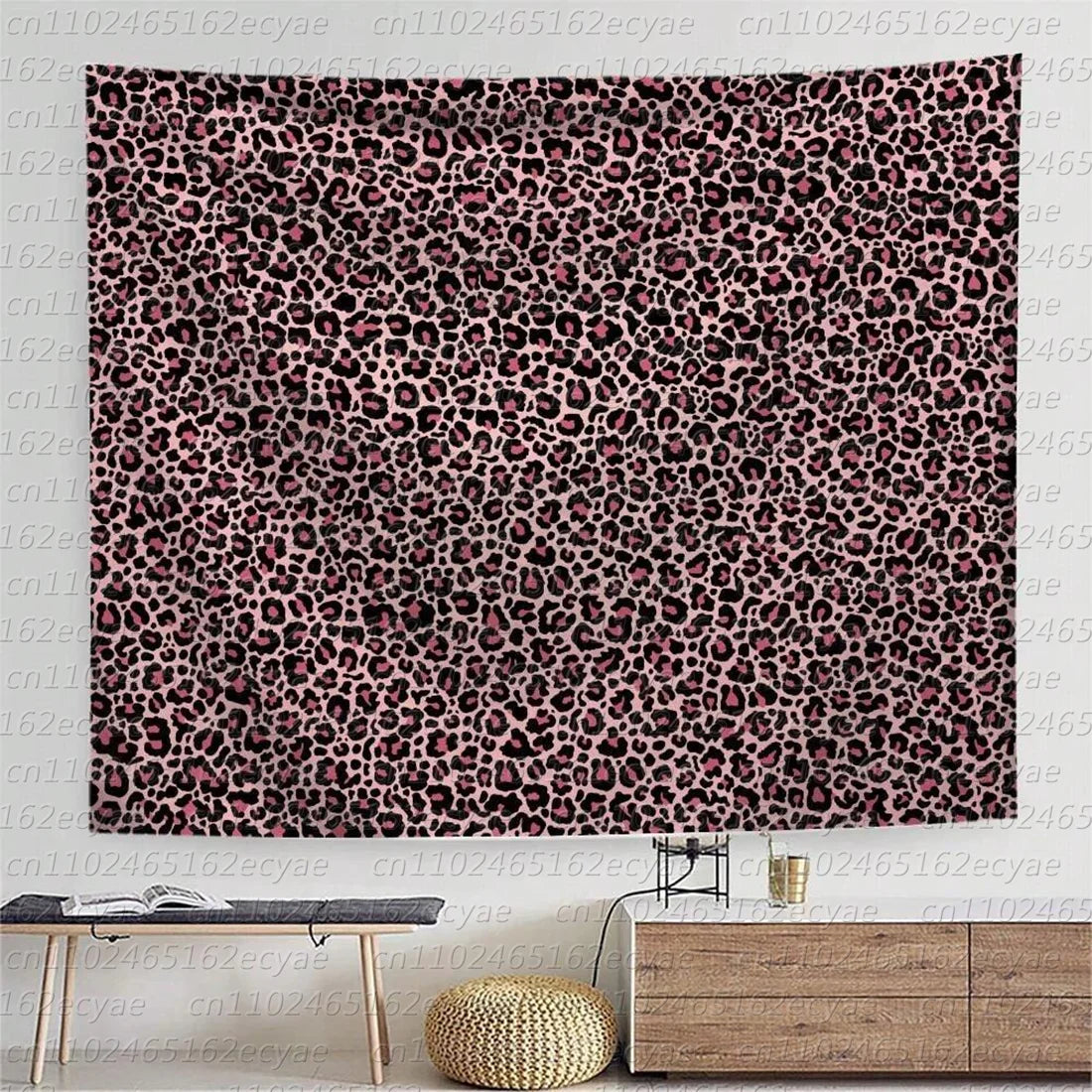 A close-up of a wall tapestry featuring a dense leopard print pattern in shades of pink and black.