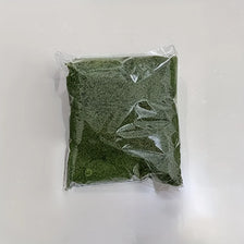 A clear plastic bag filled with green artificial moss for home decor and DIY projects.
