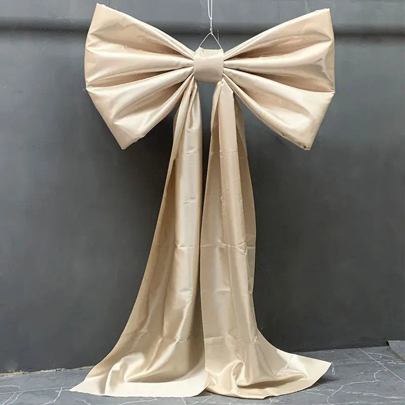A large satin bow with long tulle drape used for event decoration.