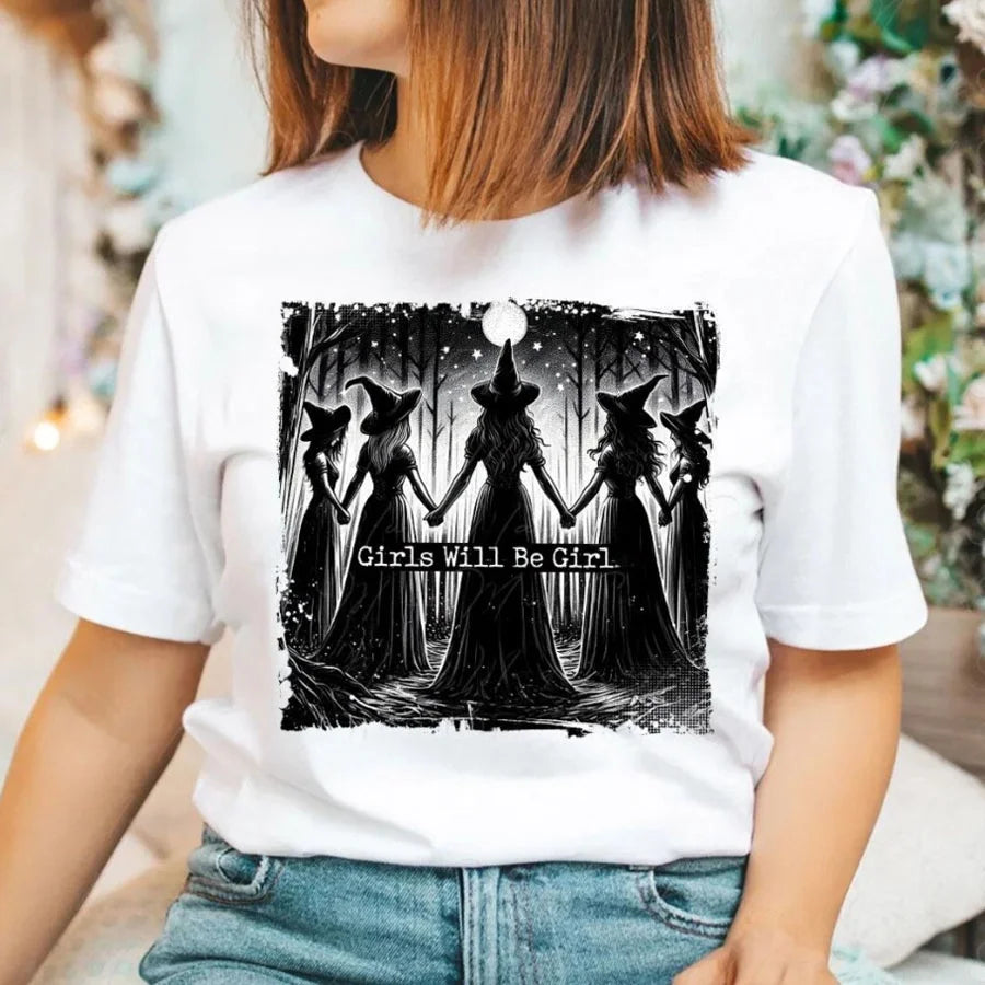 A white t-shirt featuring a black silhouette design of witches standing together.