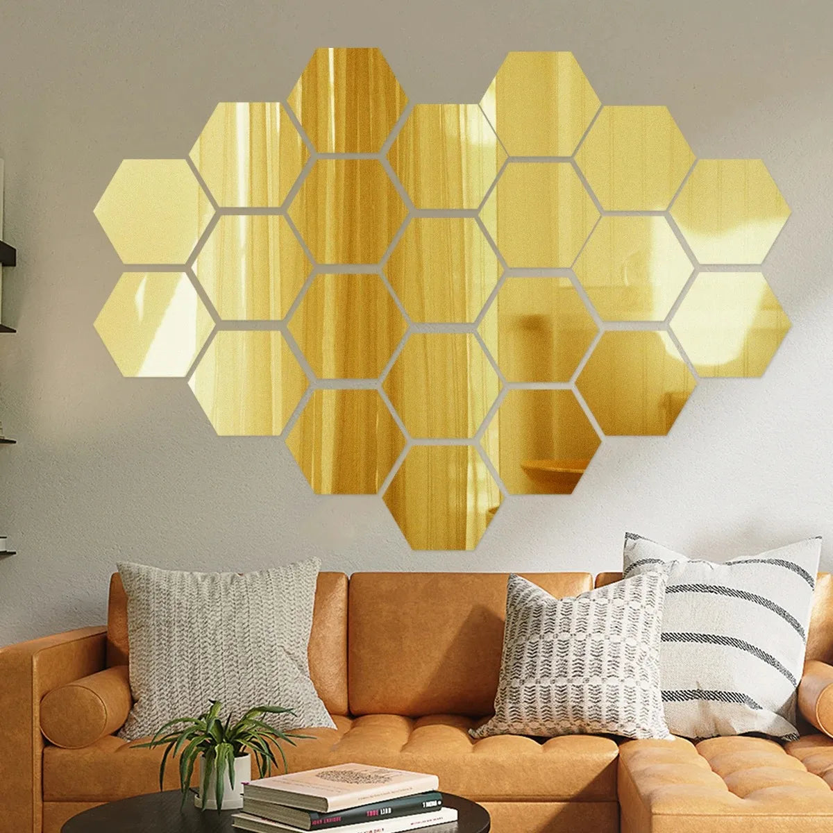 A piece of gold-toned hexagon mirror wall decor stickers mounted on a light gray wall.