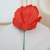 A vibrant red artificial peony flower with white veining on a green stem, used for elegant event decor.
