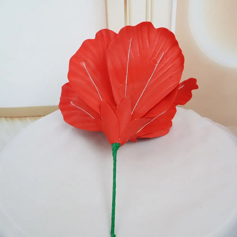 A vibrant red artificial peony flower with white veining on a green stem, used for elegant event decor.
