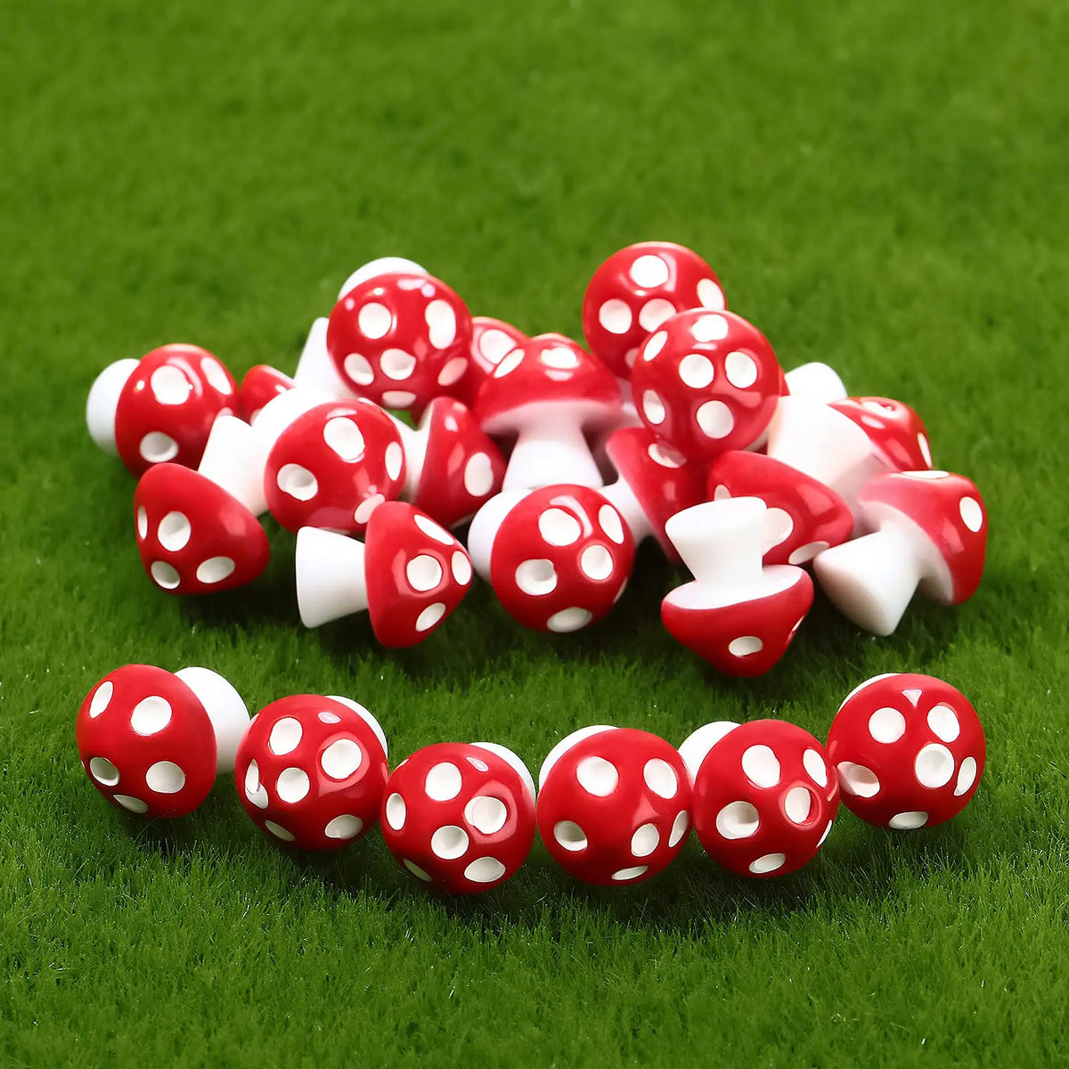 A set of red and white resin mini mushroom figurines placed on green grass.