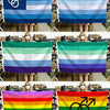 A collection of various LGBT pride flags displayed by people against a background of storage boxes.