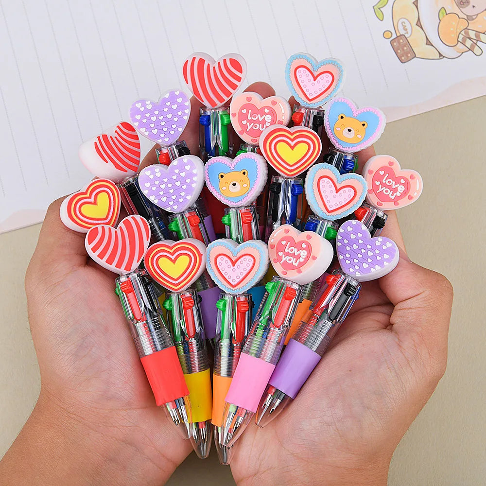 A hand holds a cluster of heart-shaped multicolor ballpoint pens for Valentine's Day