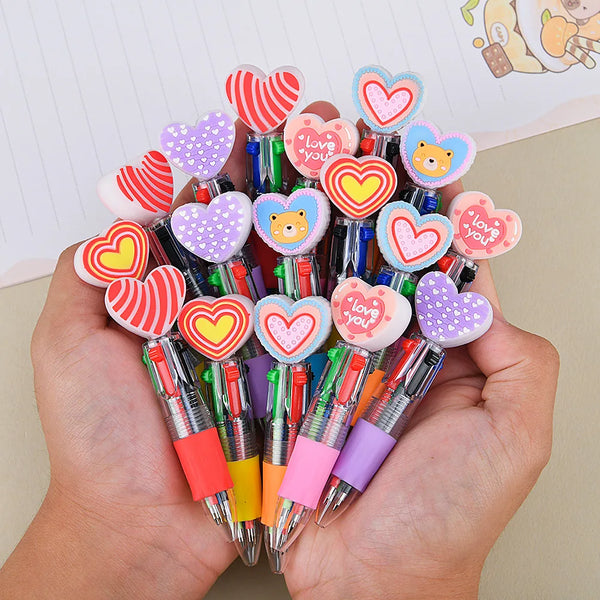 A hand holds a cluster of heart-shaped multicolor ballpoint pens for Valentine's Day