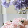 Close-up display of silk hydrangea stems in various shades of blue, purple, and pink.
