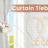 A set of natural wooden bead curtain tiebacks used to hold a light gray curtain.