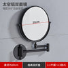 A round, black folding double-sided wall mirror with telescopic arms, shown mounted on a gray wall.