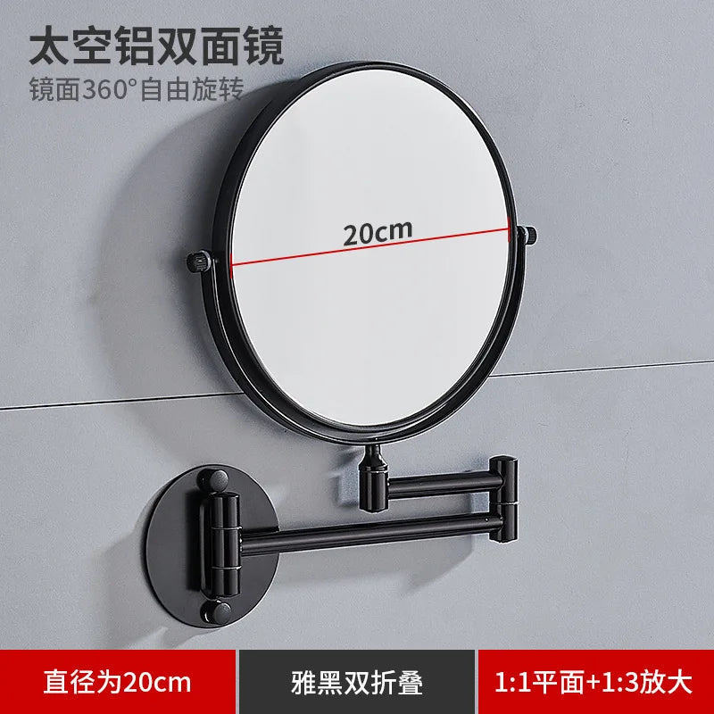 A round, black folding double-sided wall mirror with telescopic arms, shown mounted on a gray wall.