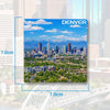 A magnet featuring a scenic view of Denver city skyline and mountains.