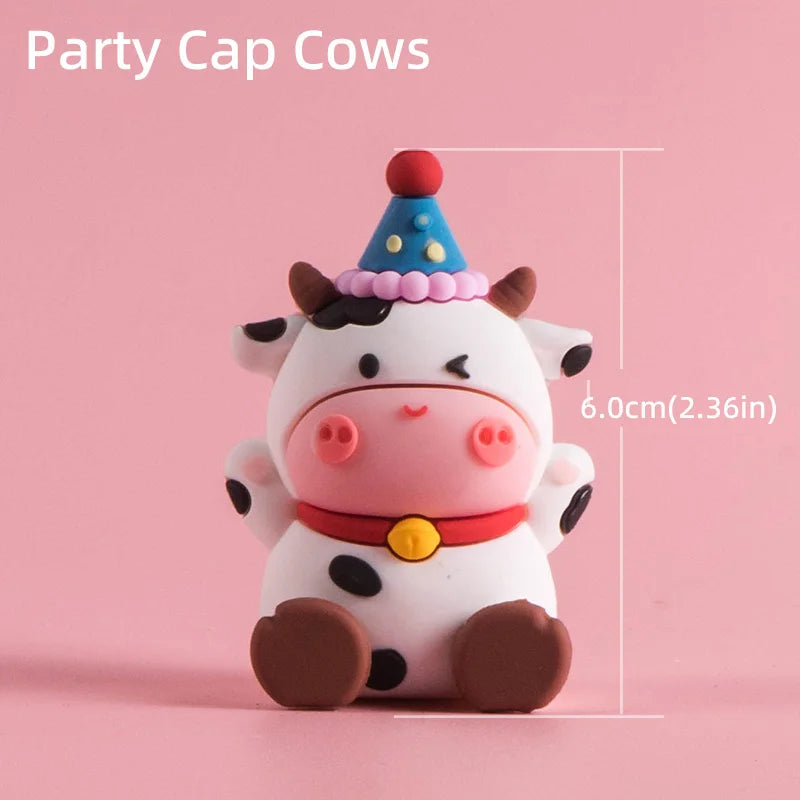 A cute white cow cake topper with a purple conical party hat and brown accents.