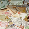 Collection de cartes et inserts de papier de journal vintage et décoratifs dans diverses nuances de crème, vert et rose.