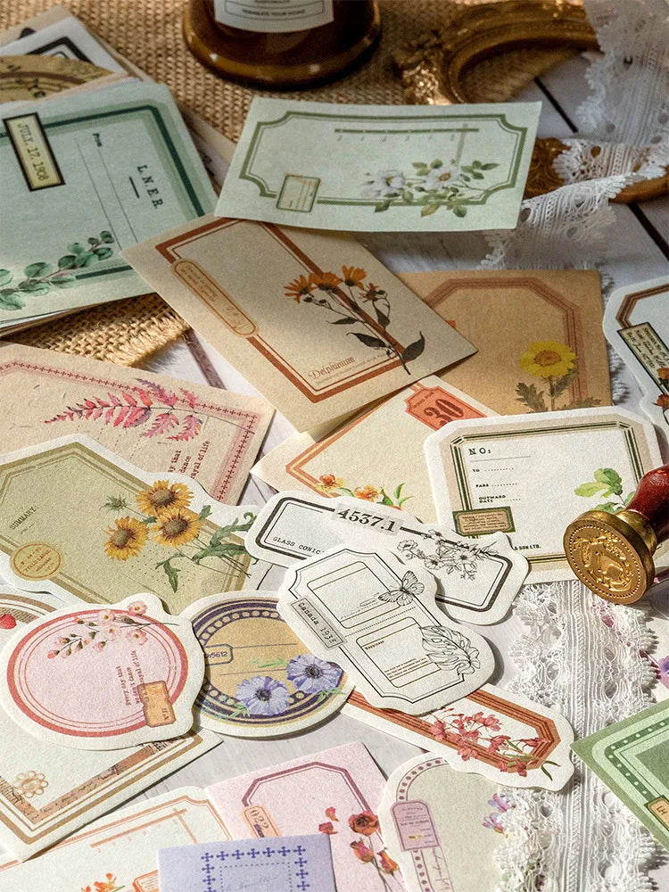 Collection de cartes et inserts de papier de journal vintage et décoratifs dans diverses nuances de crème, vert et rose.