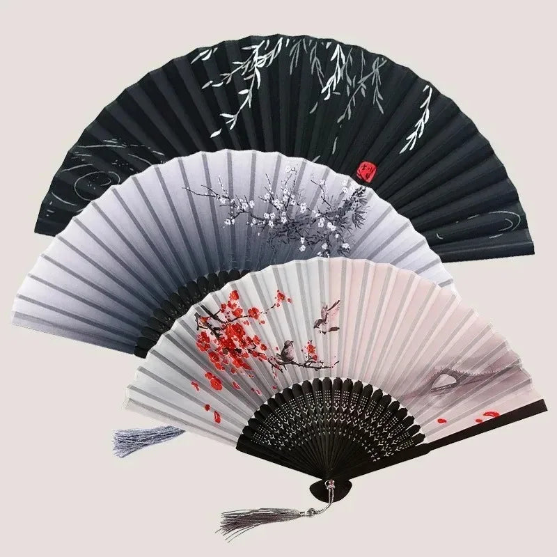 A vintage bamboo folding hand fan with black and white stripes and red floral accents.