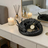 A black dragon-themed desktop storage tray organizer with gold accents sits on a white dresser next to a lit candle and a fra