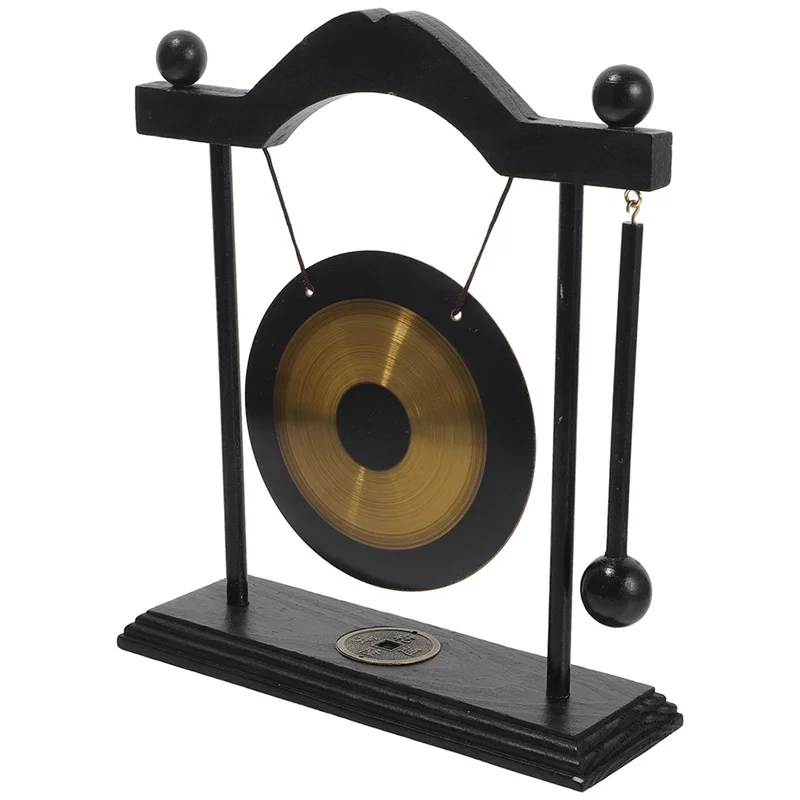 A black and brass gong decor set featuring a large circular gong suspended by a stand.