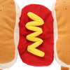 A plush costume resembling a hot dog, featuring brown and white fabric with a yellow coiled element.